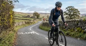Cyclist riding along a British country lane wearing a windproof cycling gilet