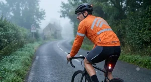 Illustration of a road cyclist wearing a high-visibility packable cycling jacket on a misty British morning.