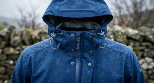 Illustration of an adjustable hooded waterproof cycling jacket with a storm flap