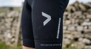 Close-up of the reflective logos and safety details on the side panel of men's bib shorts for low-light visibility.