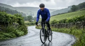Road cyclist riding along a wet country lane in a fitted waterproof cycling jacket