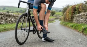Cyclist adjusting their BOA dial road cycling shoes while preparing for a weekend club ride in the UK countryside.