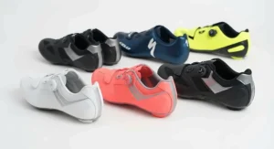 A selection of men's and women's clipless road cycling shoes arranged side-by-side in various colours.