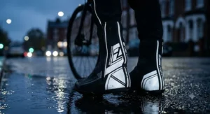Close-up of reflective high-visibility safety details on black waterproof cycling overshoes for night riding