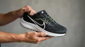 A pair of ultra-lightweight carbon sole road cycling shoes being held up to demonstrate their minimal weight.