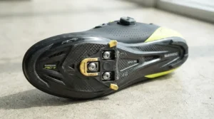 Detailed view of stiff carbon sole road shoes for racing showing cleat setup for sportives