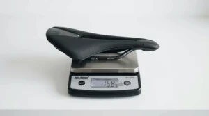 Ultra-lightweight road racing saddles resting on a digital scale in a workshop